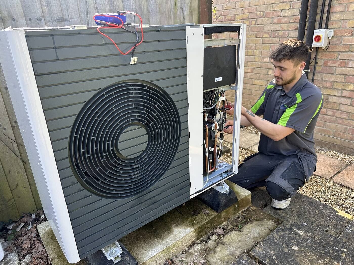 Solwat engineer repairing an air source heat pump